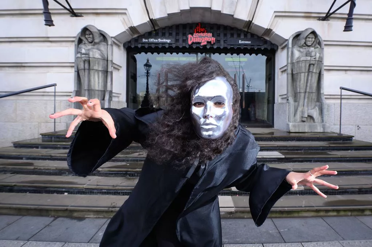 In her scary silver mask, 'The Unknown', a character from the Willy's Chocolate Experience poses outside London Dungeon