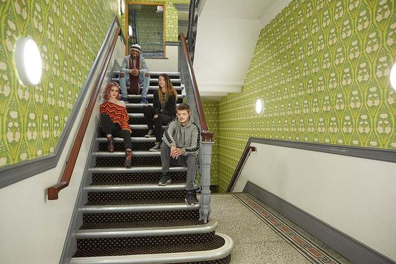 Young people sat on the stairs at the Y