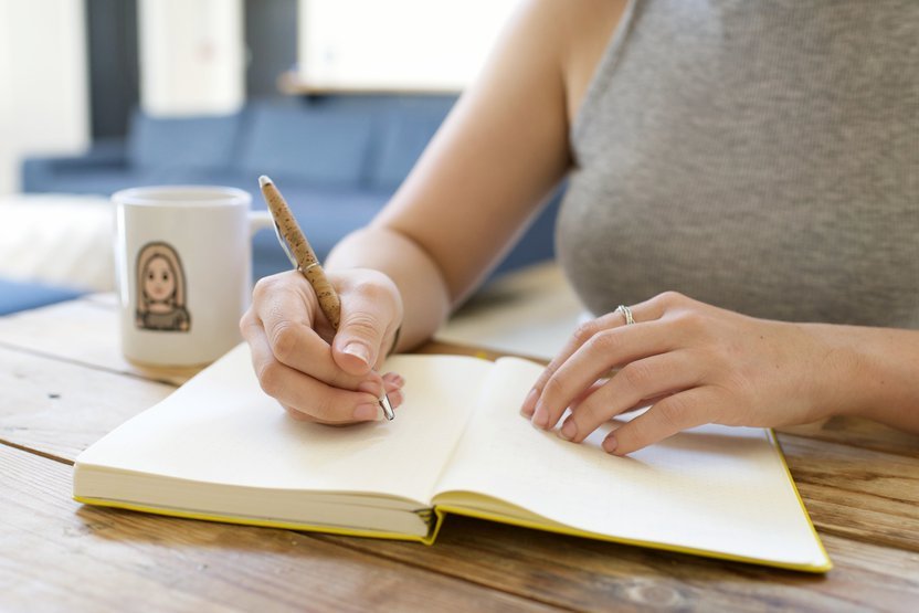 Person writing in a notebook.