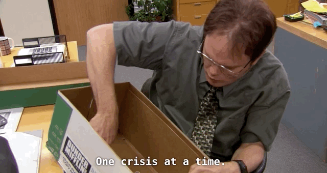 A gif of Dwight Schrute, from sitcom The Office, sorting through files. The subtitle reads 'one crisis at a time'.